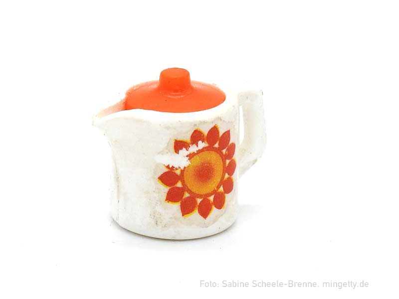 Kanne mit oragenfarbener Blume
